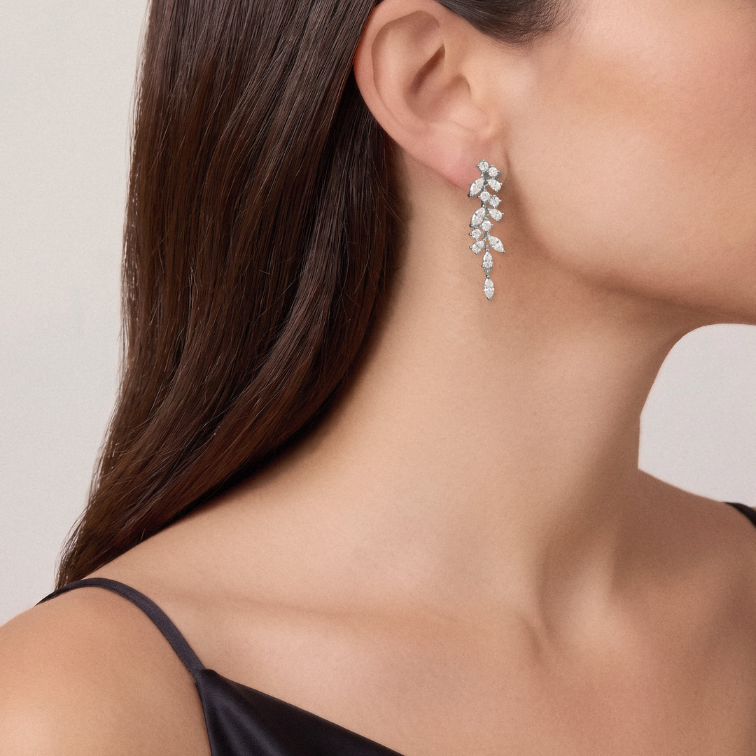 Alma Ohrringe aus 14kt. Weißgold am Ohr getragen, hängendes Diamant-Design von VEYNOU