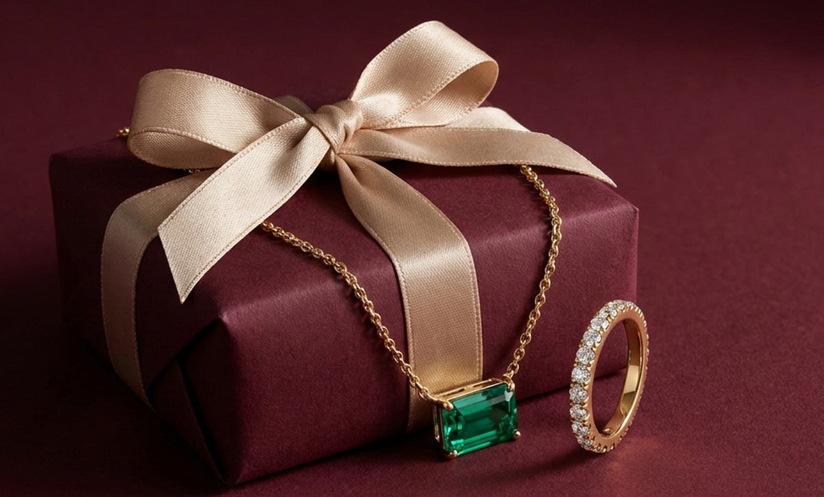 VEYNOU Eden Halskette mit Smaragd und Pavé Ring auf einer Geschenkbox mit Schleife